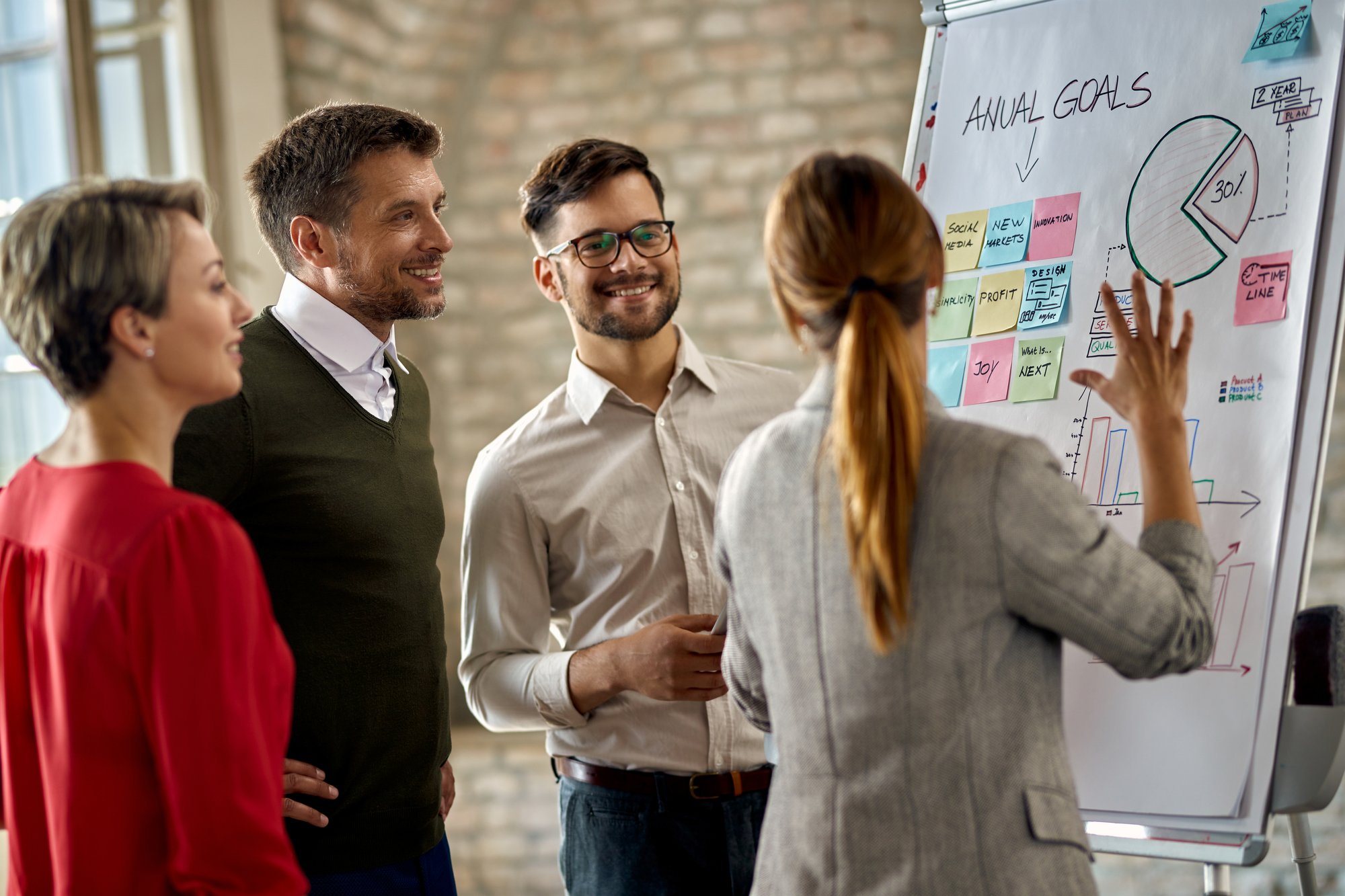 happy-business-team-cooperating-while-analyzing-their-business-progress-whiteboard-office